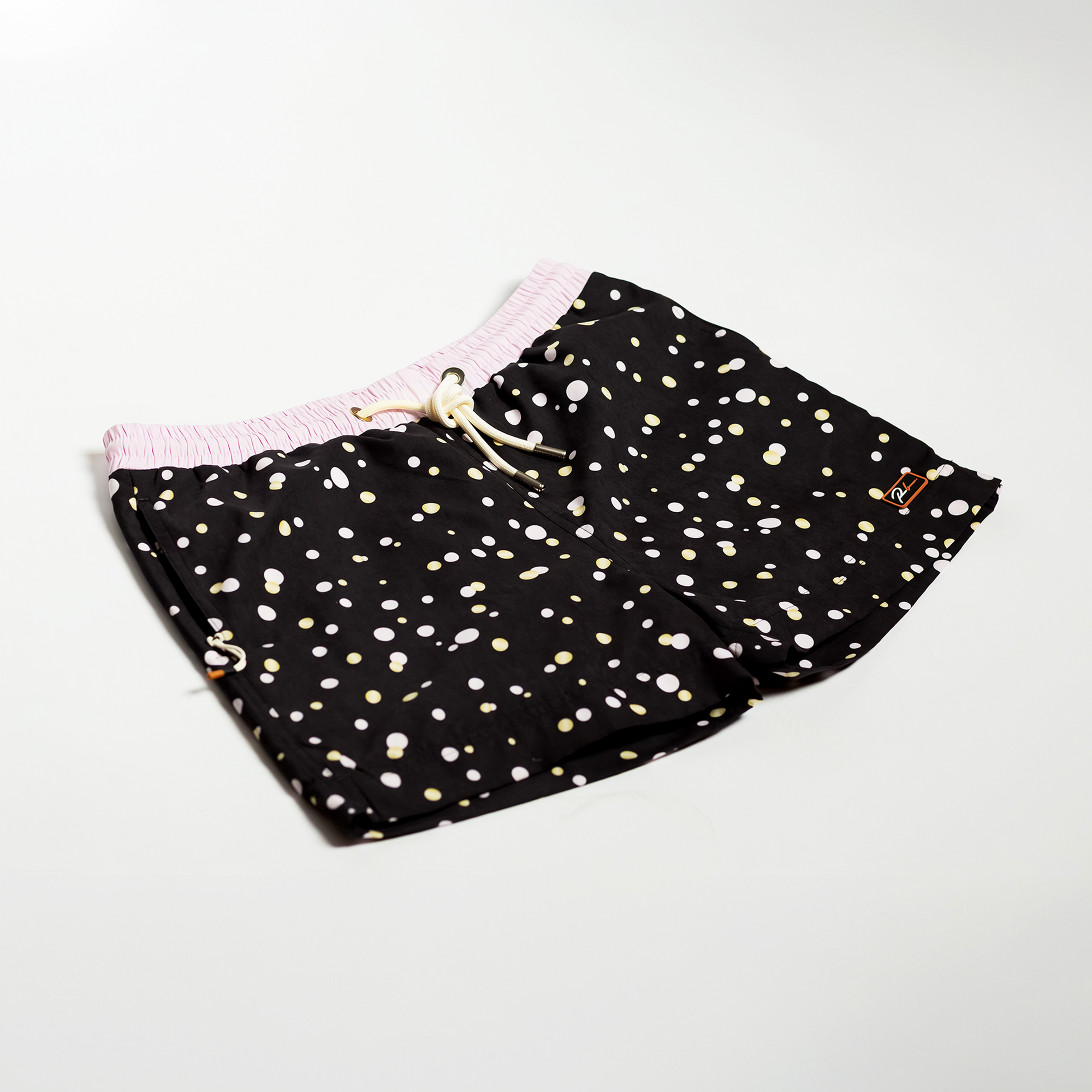 Designer Men’s Resort Wear, Swim Shorts & Luxury Swimwear Accessories | Riviera Bathers | Swim Trunks | Perlage | Black, Pink, and Gold Champagne Bubbles