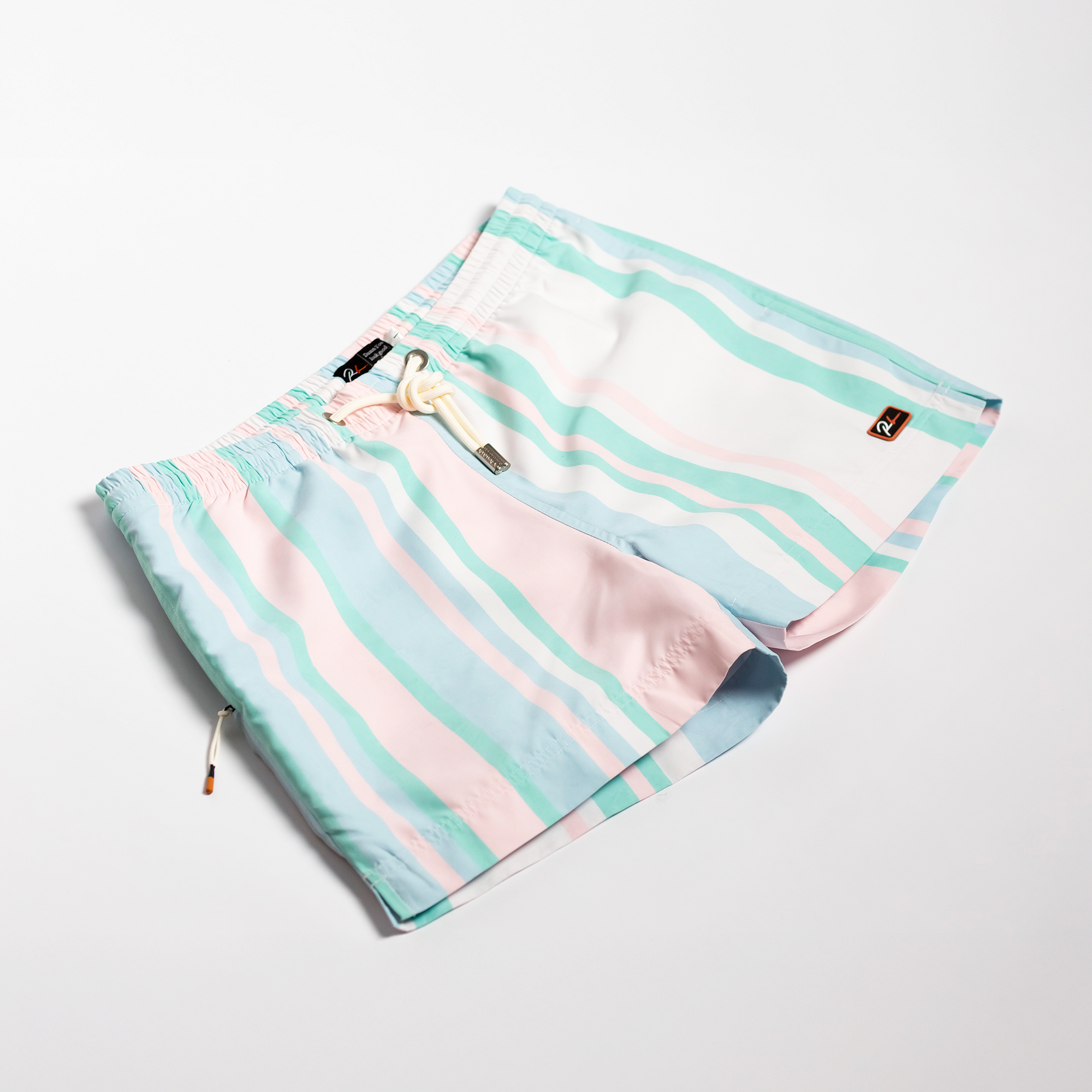Designer Men’s Resort Wear, Swim Shorts & Luxury Swimwear Accessories | Riviera Bathers | Swim Trunks | Rancho Mirage | Pink, Green, Peach, and White Stripes